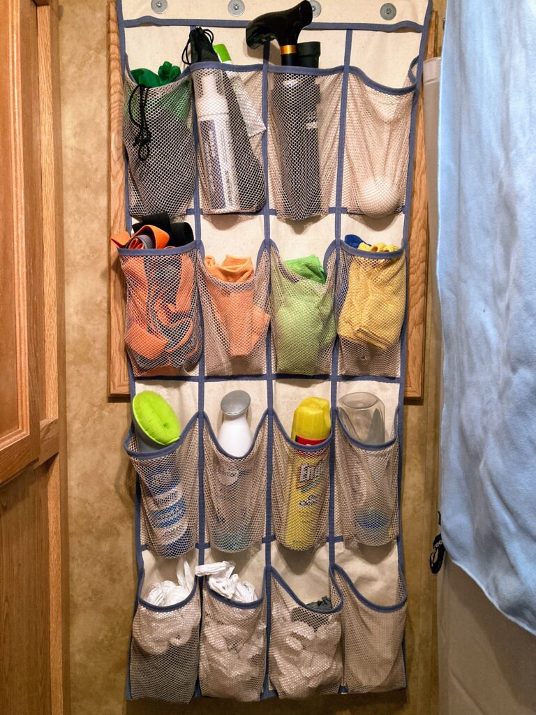Hanging a shoe pocket organizer over the toilet to keep bathroom items organized